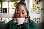 Mulher tomando café em uma cafeteria