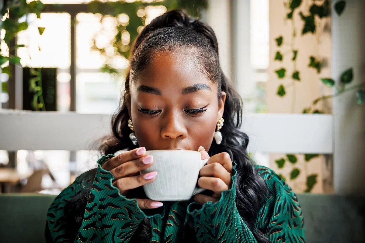 Mulher tomando café em uma cafeteria