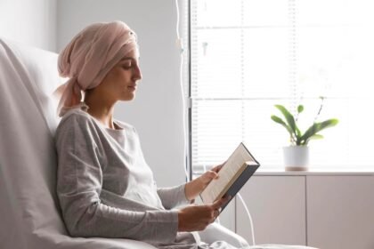 Paciente com lenço na cabeça lendo um livro