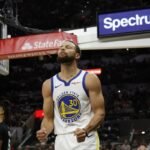 Stephen Curry comemora em quadra com a camisa do Golden State