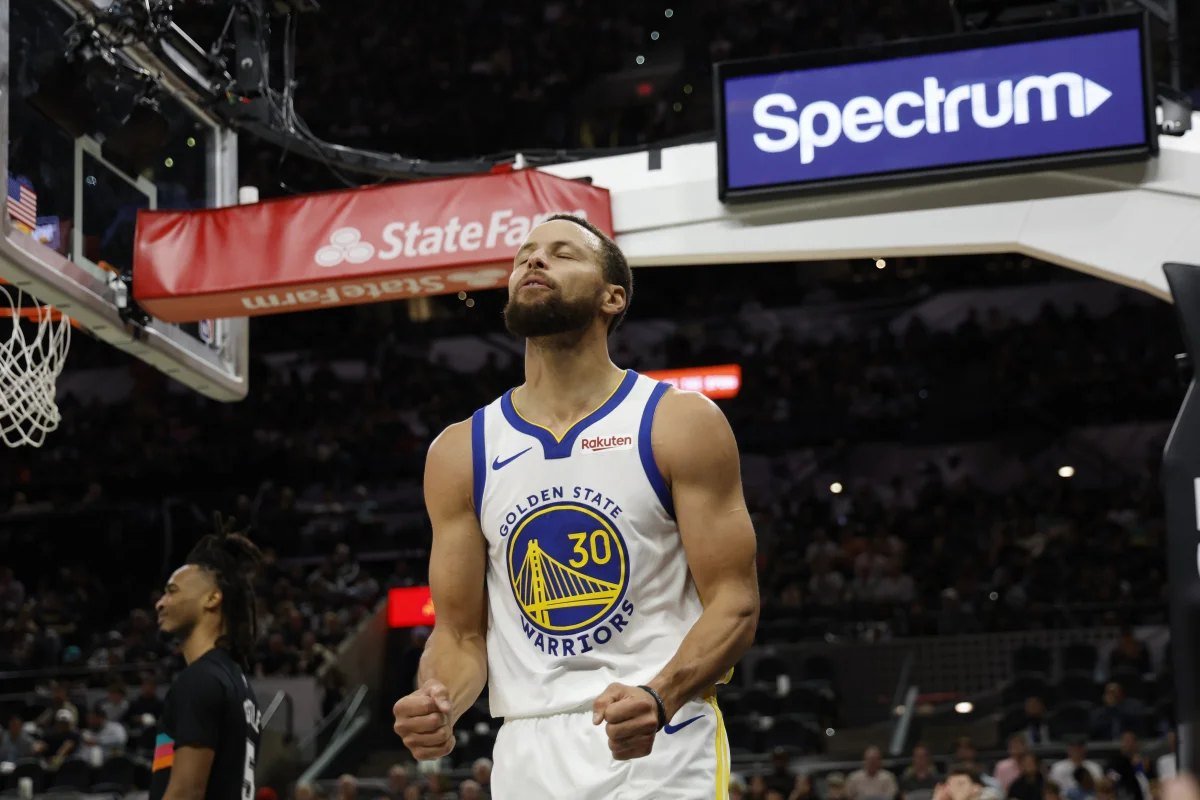 Stephen Curry comemora em quadra com a camisa do Golden State