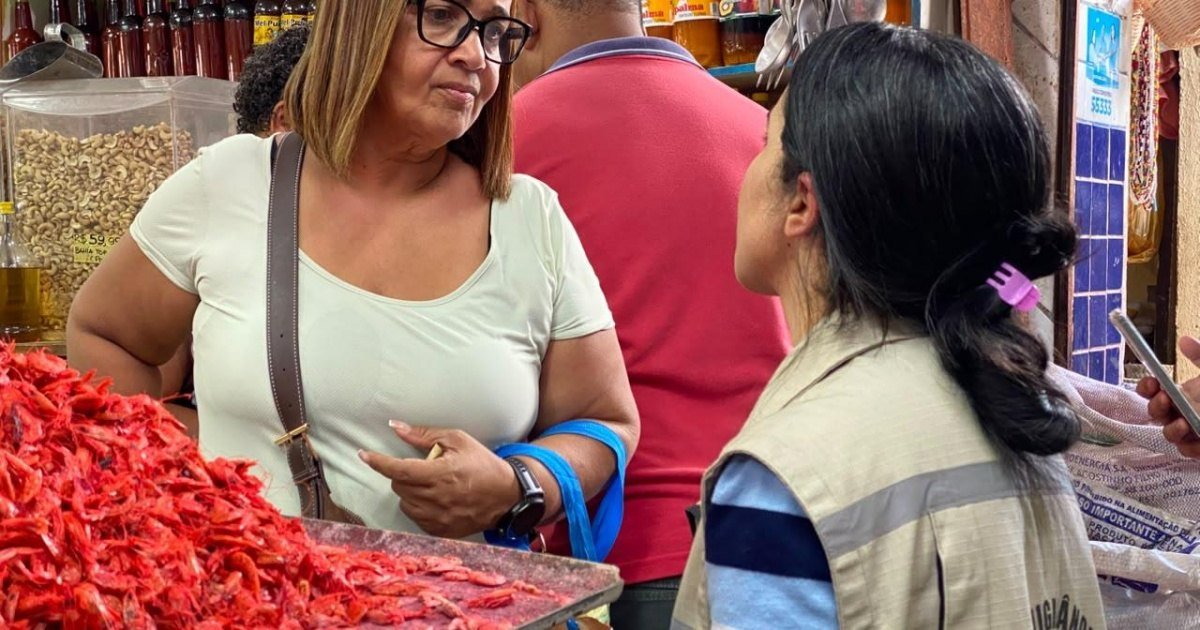 Fiscal da Vigilância Sanitária conversa com comerciante em feira de Salvador