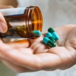 Pessoa segurando cápsulas de medicamento