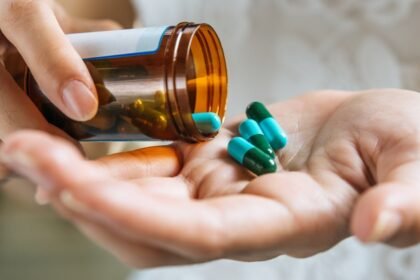 Pessoa segurando cápsulas de medicamento