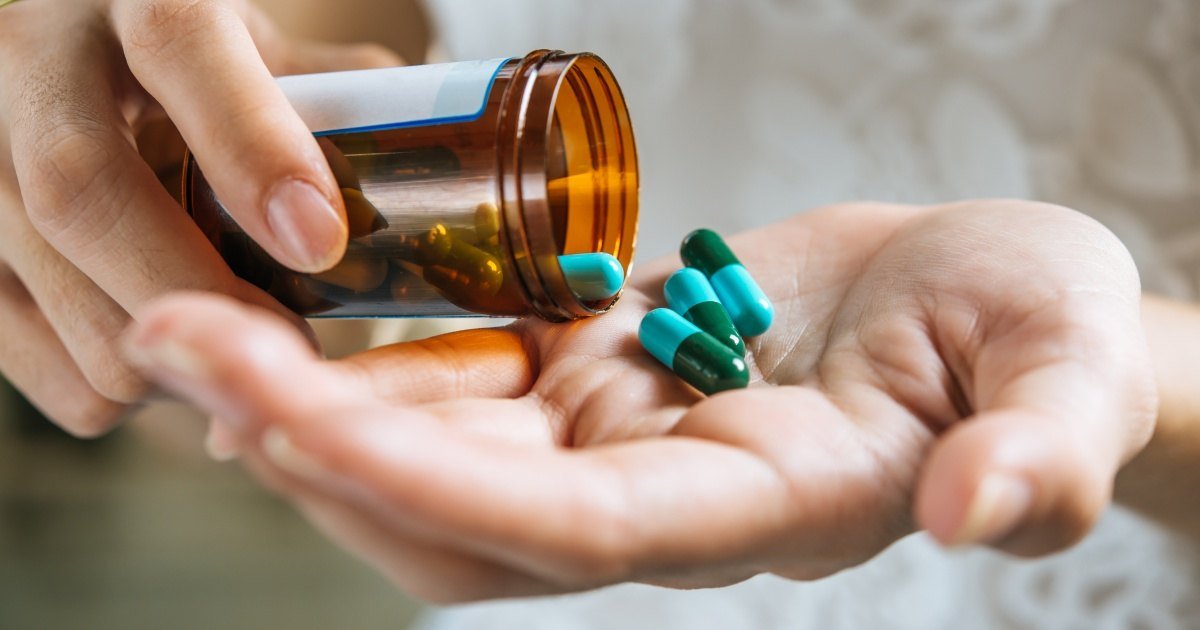 Pessoa segurando cápsulas de medicamento