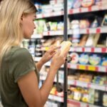 Consumidora lendo o rótulo de um produto no supermercado
