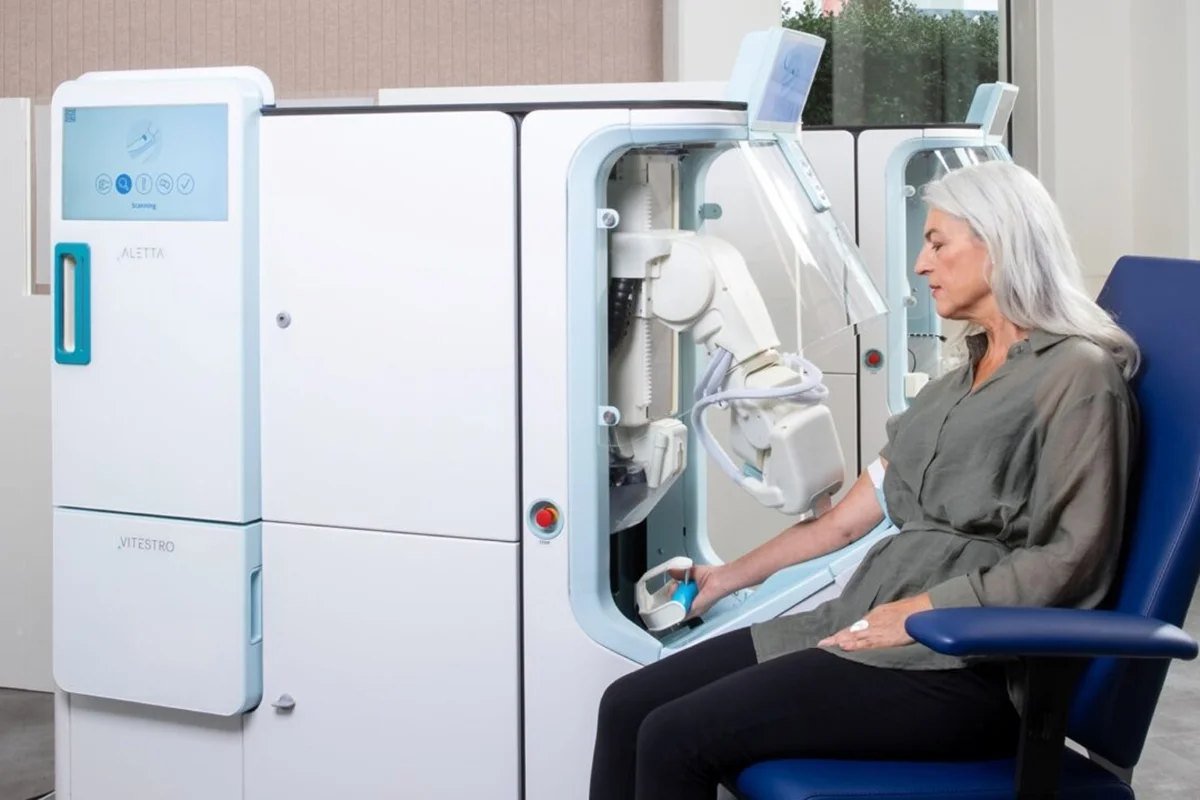 Equipamento robótico de coleta de sangue com uma paciente sentada
