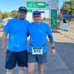 Pai e filho sorrindo juntos em evento de corrida