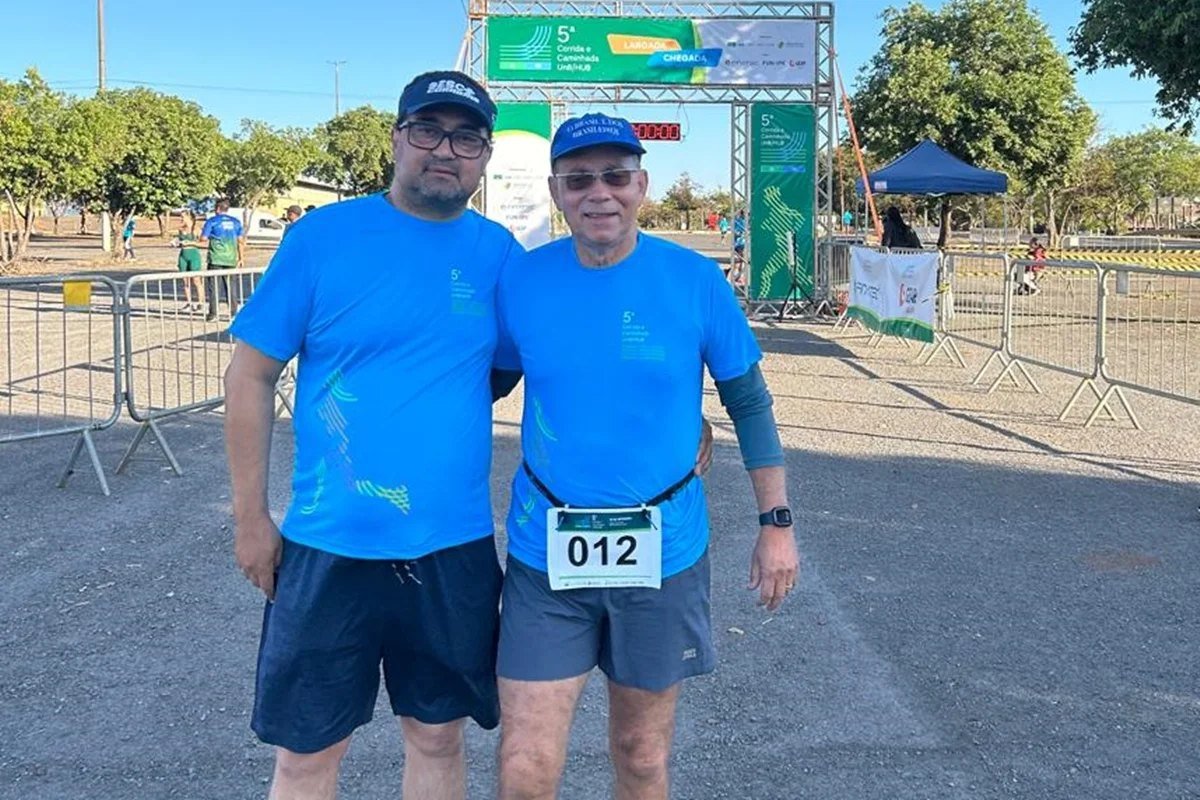Pai e filho sorrindo juntos em evento de corrida