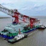 Navio de cravação de estacas com guindaste vermelho navegando