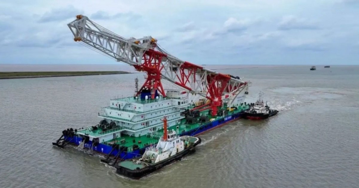 Navio de cravação de estacas com guindaste vermelho navegando
