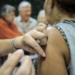 Idosa recebe vacina no braço em posto de saúde