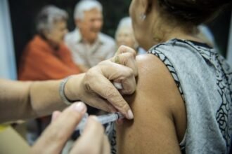 Idosa recebe vacina no braço em posto de saúde