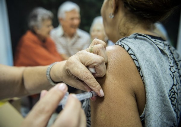 Idosa recebe vacina no braço em posto de saúde