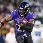 Jogador do Baltimore Ravens correndo com a bola