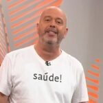 Alex Escobar no estúdio com camisa branca escrita saúde