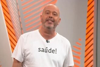 Alex Escobar no estúdio com camisa branca escrita saúde