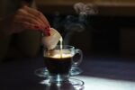 Café sendo coado em uma xícara de vidro