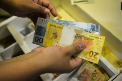 Mãos contando cédulas de real