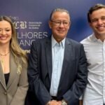 Três pessoas sorriem em painel do Prêmio ACB Melhores do Ano
