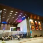 Fachada iluminada do Centro Cultural Novo Mané Dendê à noite