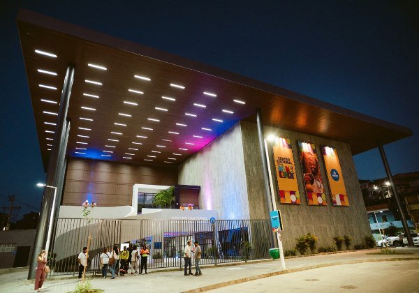 Fachada iluminada do Centro Cultural Novo Mané Dendê à noite