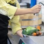 Pessoa escolhe frutas e verduras frescas em feira livre