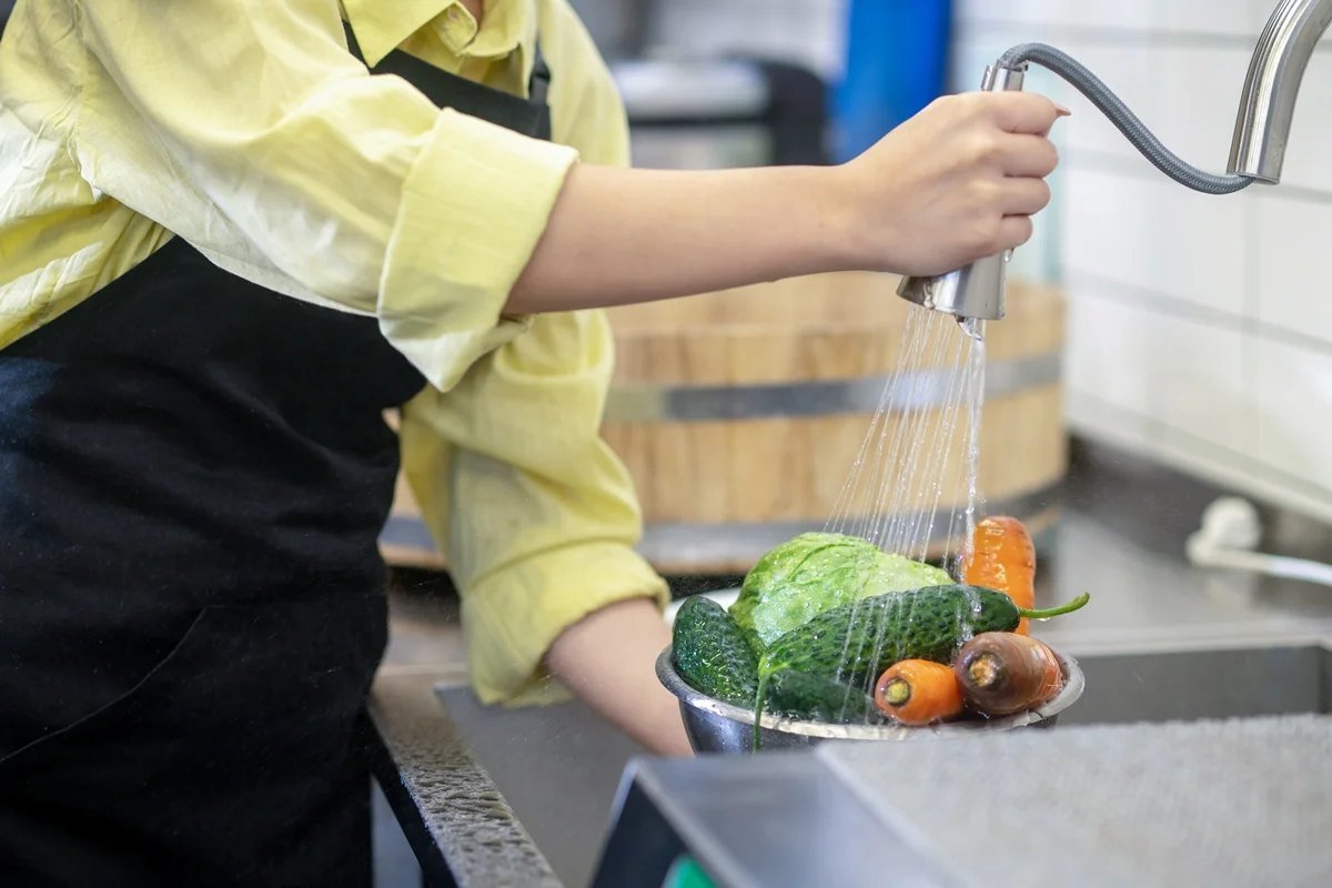 Pessoa escolhe frutas e verduras frescas em feira livre