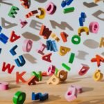 Letras coloridas de brinquedo espalhadas sobre a mesa