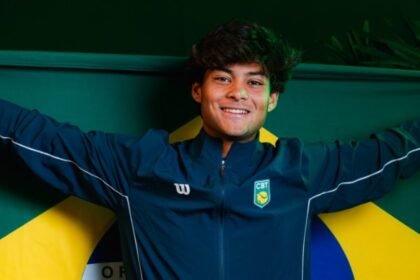 Tenista Guto Miguel com uniforme do Brasil e braços abertos