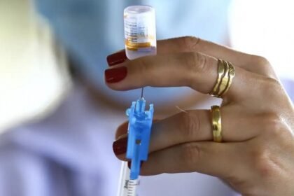 Profissional de saúde segura seringa e frasco de vacina