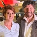 Mila Seidl e Lito Sousa posam juntos em frente a aviões