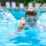 Criança nadando em piscina
