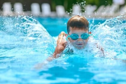 Criança nadando em piscina