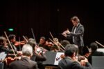 Maestro rege a Orquestra Sinfônica da Bahia no palco