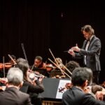Maestro rege a Orquestra Sinfônica da Bahia no palco