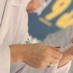 Mão com luva prepara aplicação de injeção