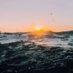 Mar agitado com ondas sob céu ao entardecer