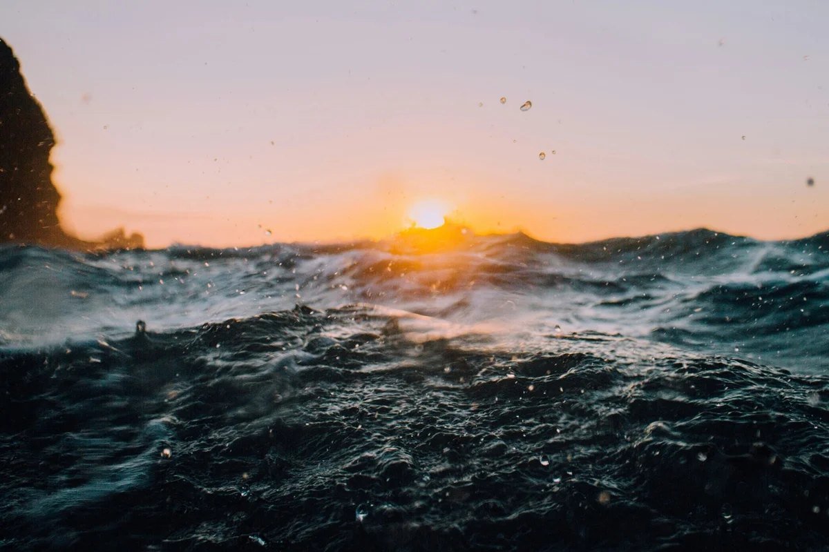 Mar agitado com ondas sob céu ao entardecer