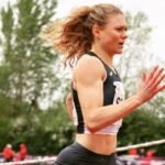 Velocista Beth Dobbin correndo em pista de atletismo