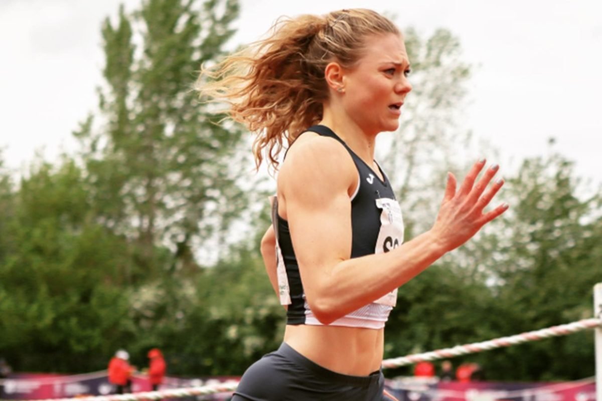 Velocista Beth Dobbin correndo em pista de atletismo